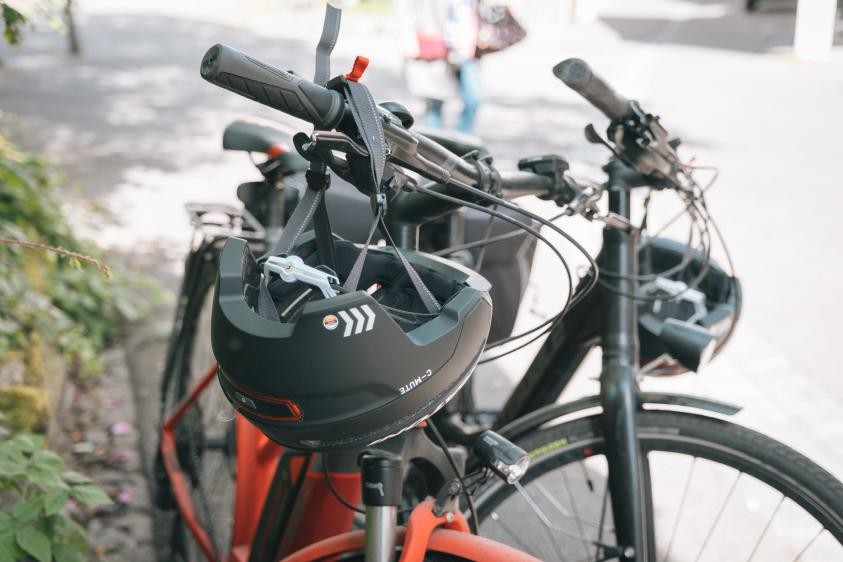 Zwei abgestellte Fahrräder mit einem schwarzen Helm am Lenkrad